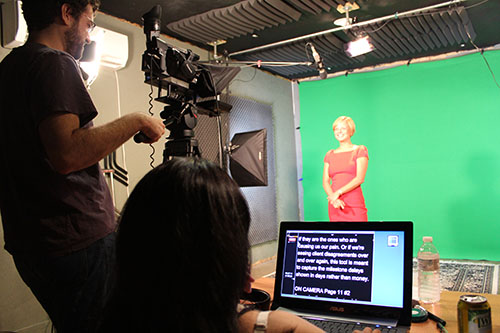 An actress being filmed in a green screen studio.